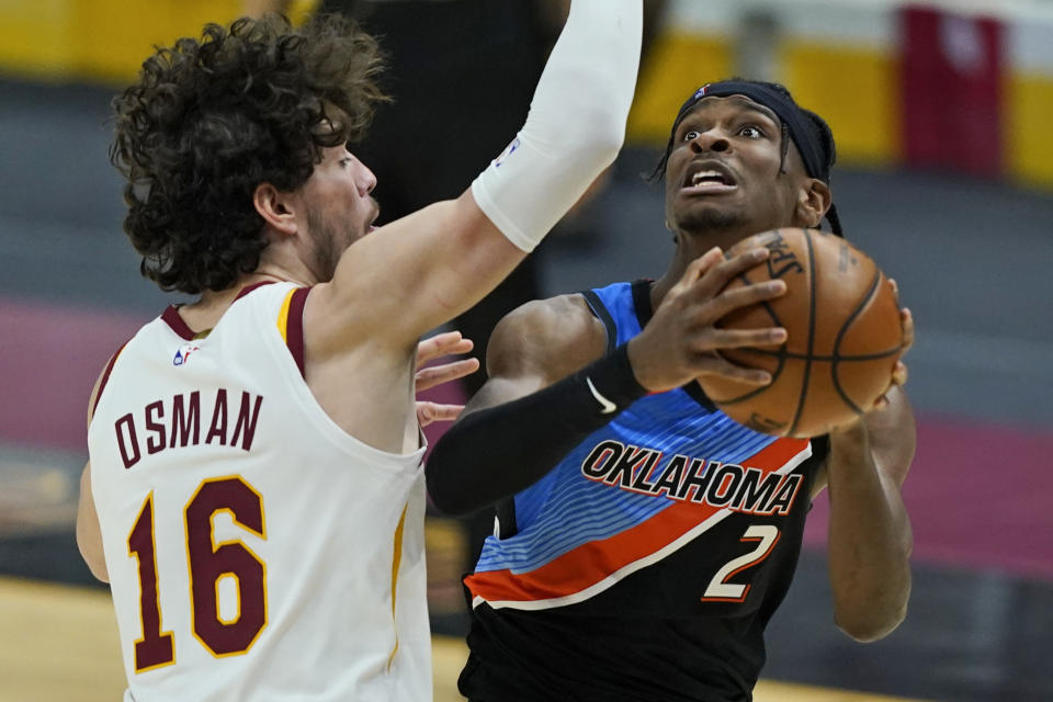 Oklahoma City Thunder's Shai Gilgeous-Alexander (2) drives to the basket against Cleveland Cavaliers' Cedi Osman (16) in the second half of an NBA basketball game, Sunday, Feb. 21, 2021, in Cleveland. (AP Photo/Tony Dejak)