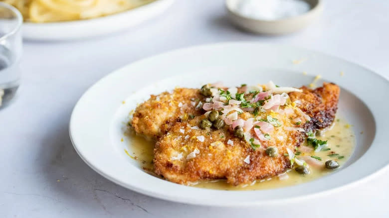 Chicken piccata on white plate