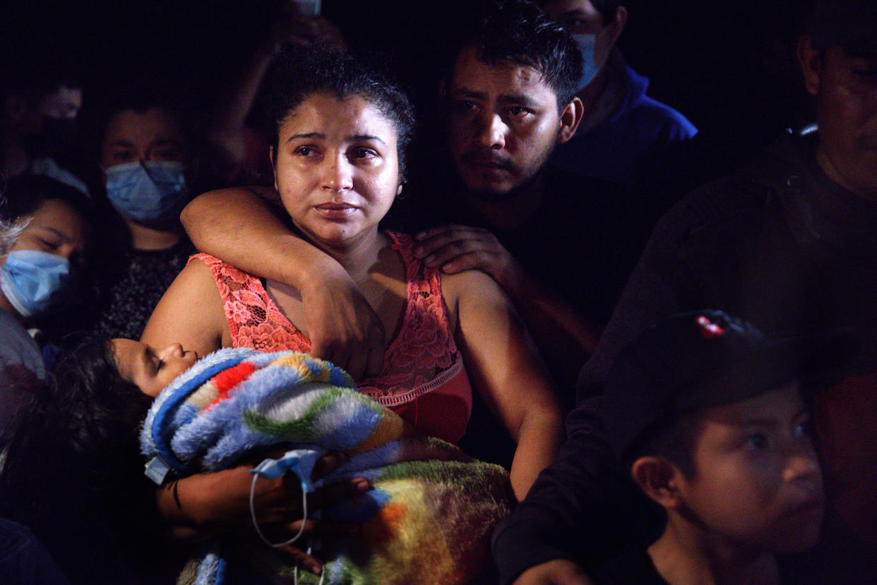 Honduran parents hold their sleeping boy after crossing the Rio Grande from Mexico in Roma, Texas, on April 15, 2021.