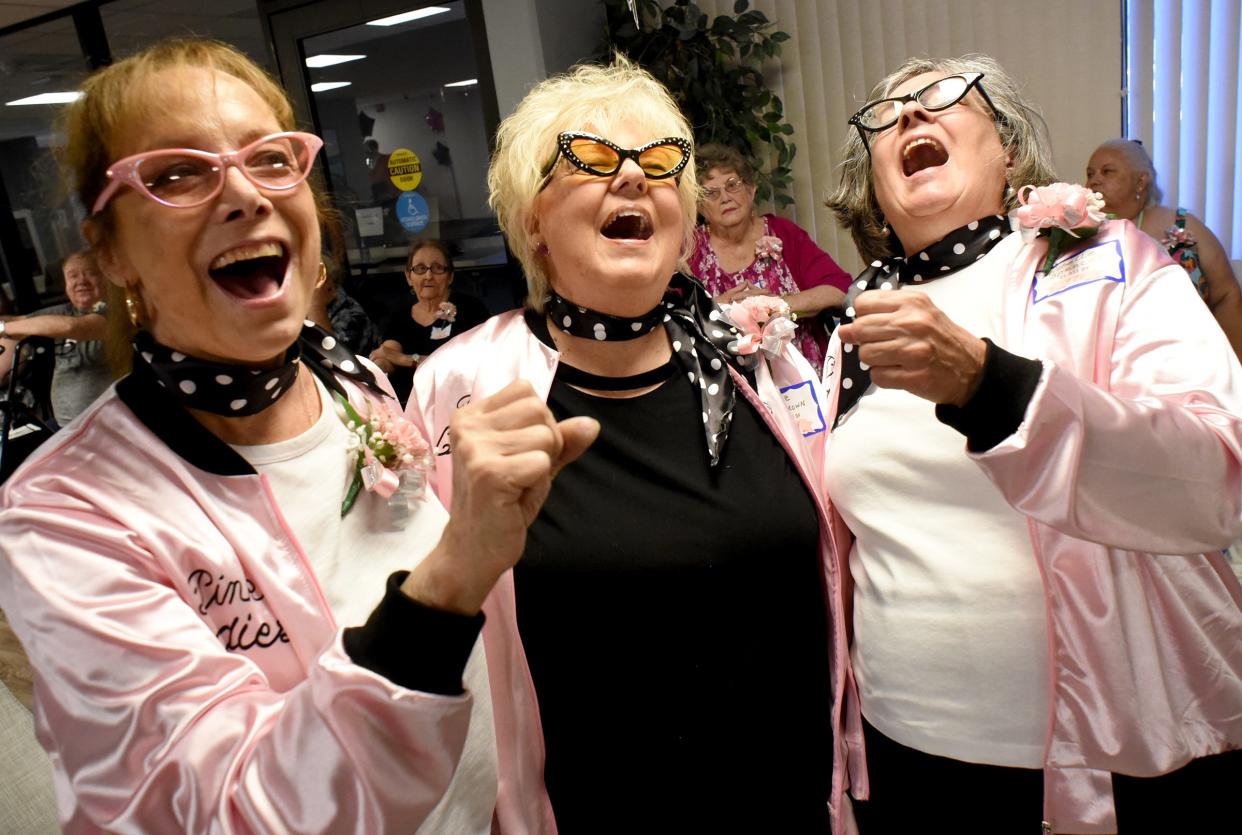 Toni Giarmo, Monroe High School Class of 1972; Rose Brown, Lincoln Park High School Class of 1964; and Michelle Spencer, Lamphere High School Class of 1970, sing "Summer Nights" from the movie "Grease" June 2 as they dressed as the movie's "Pink Ladies" at the first senior prom at the Mable H. Kehres apartments.