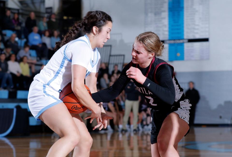 Lansing Catholic's Gabby Halliwill, left, and Portland's Malia Thelen vie for the ball, Tuesday, Jan. 9, 2024, in Lansing.