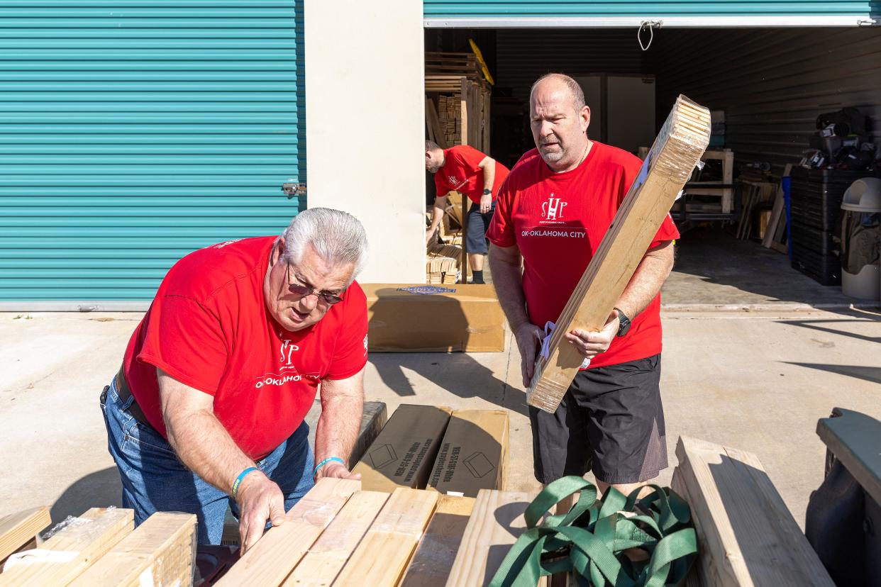 Volunteers with the Oklahoma City chapter of Sleep in Heavenly Peace load a truck with materials for a bed delivery.