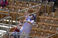 A fan reaches up to catch a foul ball hit by San Francisco Giants' Curt Casali during the fourth inning of the team's spring training baseball game against the Chicago White Sox on Monday, March 22, 2021, in Phoenix. (AP Photo/Ross D. Franklin)