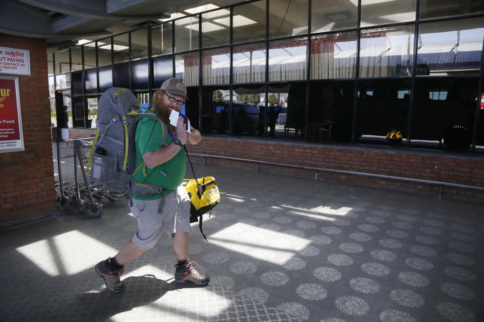 An American citizen arrives to board a Qatar Airways flight at the Tribhuvan International Airport in Kathmandu, Nepal, Tuesday, March 31, 2020. Several American citizens are stranded in Nepal due to the nationwide lockdown enforced in an attempt to stop the coronavirus spread. The new coronavirus causes mild or moderate symptoms for most people, but for some, especially older adults and people with existing health problems, it can cause more severe illness or death. (AP Photo/Niranjan Shrestha)