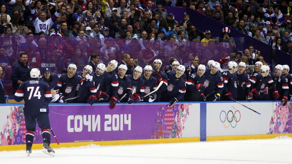 USA forward T.J. Oshie is greeted by teammates after scoring a goal against Russia during a shootout of a men's ice hockey game at the 2014 Winter Olympics, Saturday, Feb. 15, 2014, in Sochi, Russia. (AP Photo/Julio Cortez)