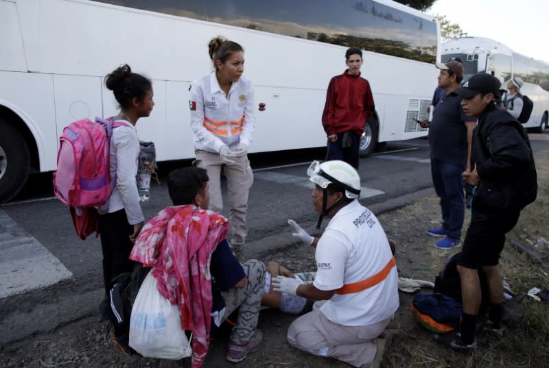 A migrant is assisted next to buses near Frontera Hidalgo