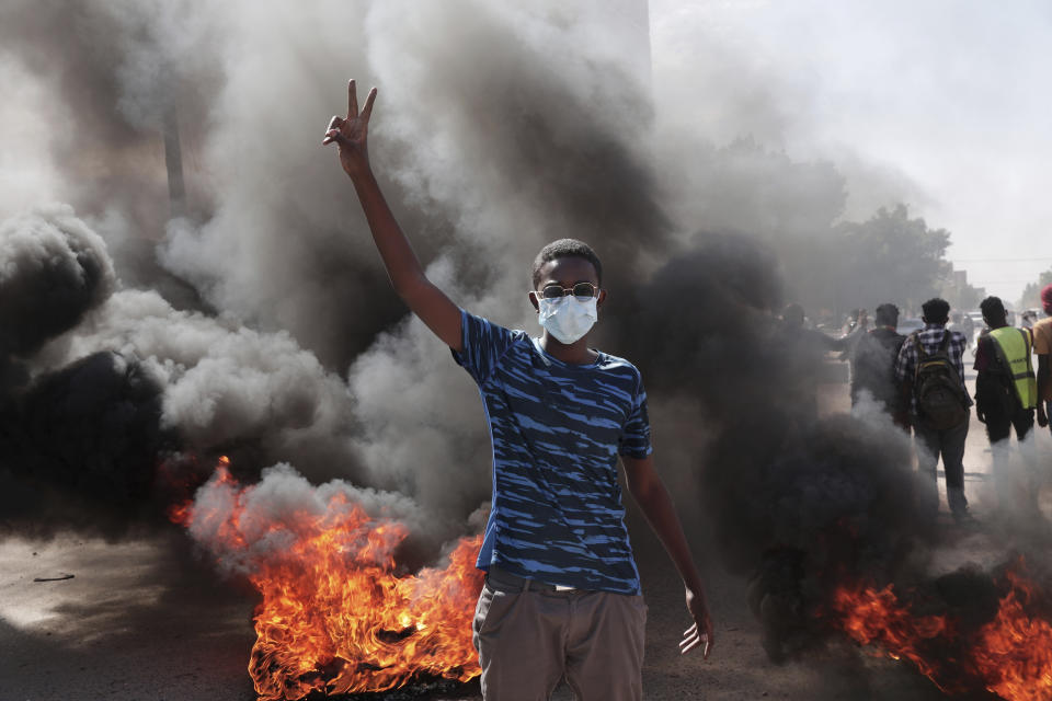 A man flashes the victory sign during a protest to denounce the October military coup, in Khartoum, Sudan, Saturday, Dec. 25, 2021. Sudanese security forces fired tear gas to disperse protesters as thousands rallied since earlier in the day, even as authorities tightened security across Khartoum, deploying troops and closing all bridges over the Nile River linking the capital with its twin city of Omdurman and the district of Bahri, the state-run SUNA news agency reported.(AP Photo/Marwan Ali)
