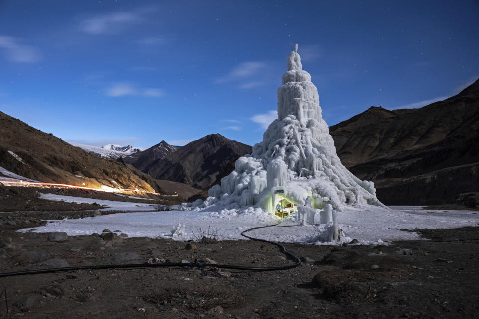 In this image released by World Press Photo, Thursday April 15, 2021, by Ciril Jazbec for National Geographic, titled One Way to Fight Climate Change: Make Your Own Glaciers, which won the second prize in the Environment Stories category, shows the youth group that built this ice stupa in the village of Gya installed a café in its base in India, March 19, 2019. They used the proceeds to take the village elders on a pilgrimage. (Ciril Jazbec for National Geographic, World Press Photo via AP)