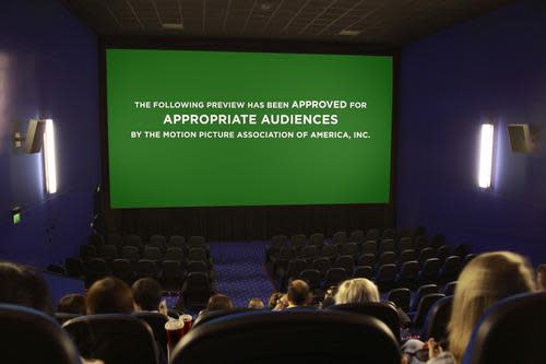 A moviegoing audience watches trailers