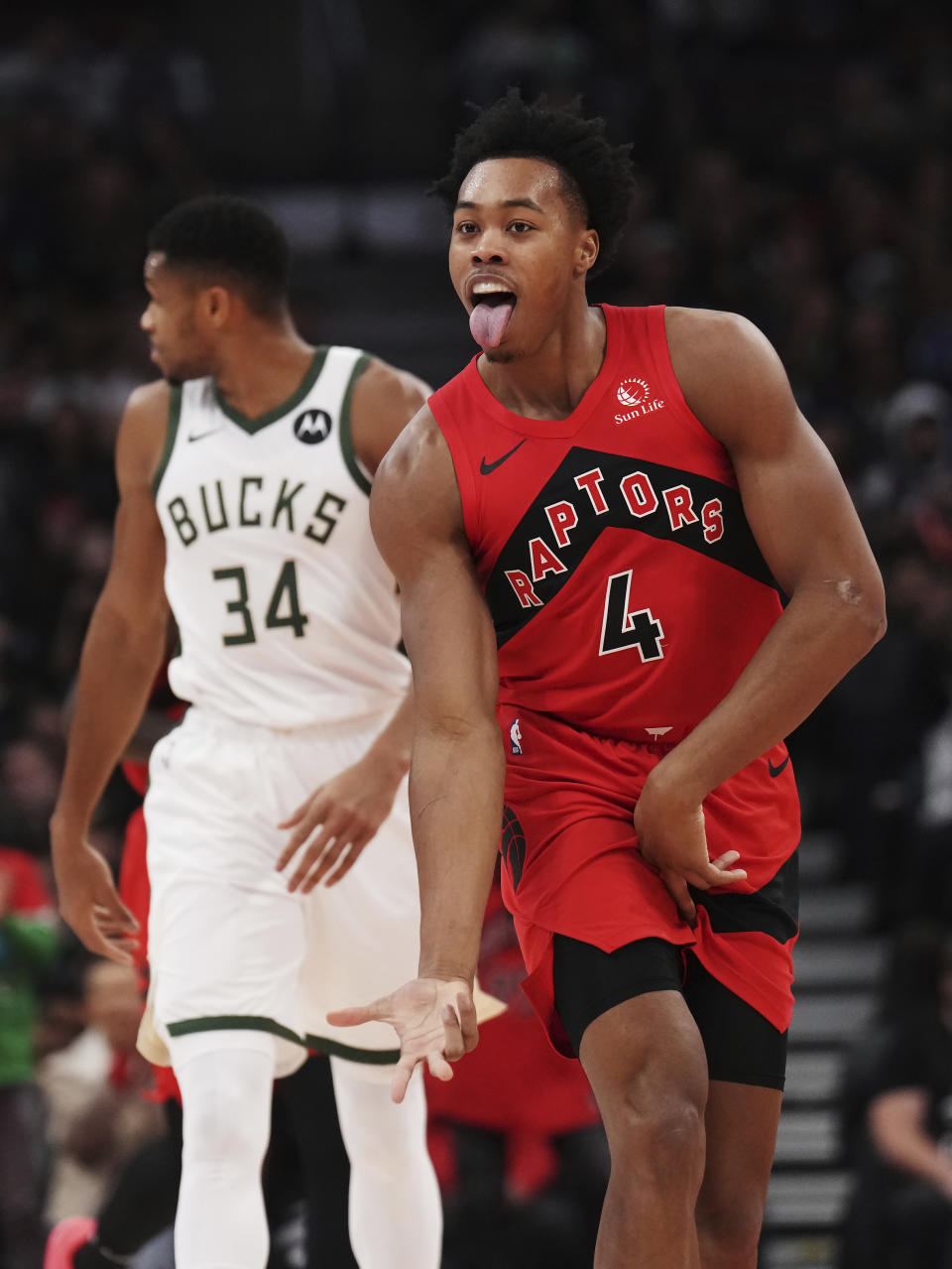 Toronto Raptors forward Scottie Barnes (4) celebrates a basket, near Milwaukee Bucks forward Giannis Antetokounmpo (34) during the first half of an NBA basketball game Wednesday, Nov. 1, 2023, in Toronto. (Nathan Denette/The Canadian Press via AP)