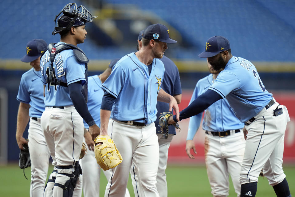 Tampa Bay Rays starting pitcher Jeffrey Springs is congratulated by catcher Christian Bethancourt (14) and first baseman Yandy Diaz (2) after being taken out against the Philadelphia Phillies during the fifth inning of a spring training baseball game Wednesday, March 22, 2023, in St. Petersburg, Fla. (AP Photo/Chris O'Meara)