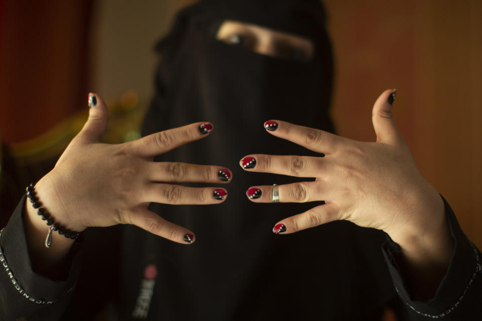 In this March 4, 2020, photo, Bardis Assayaghi, who was detained by Houthis in Yemen, poses for a portrait with her manicure in the colors of the Yemeni flag, in her home near Cairo, Egypt. Assayaghi, a prominent poet who circulated verses about Houthi repression, was detained last fall in a school and counted around 120 women held there. Some nights, the head of the Sanaa criminal investigation division, Sultan Zabin, took the “young, pretty girls” out of the school to rape them, another former detainee Samera al-Huri and Assayaghi said. (AP Photo/Maya Alleruzzo)