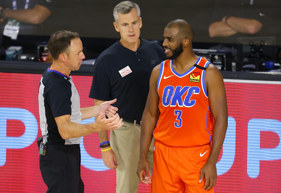 Oklahoma City Thunder's Chris Paul (3) talks with referee Josh Tiven, left, as coach Billy Donovan looks on during the third quarter of an NBA basketball game against the Phoenix Suns, Monday, Aug. 10, 2020, in Lake Buena Vista, Fla. (Mike Ehrmann/Pool Photo via AP)