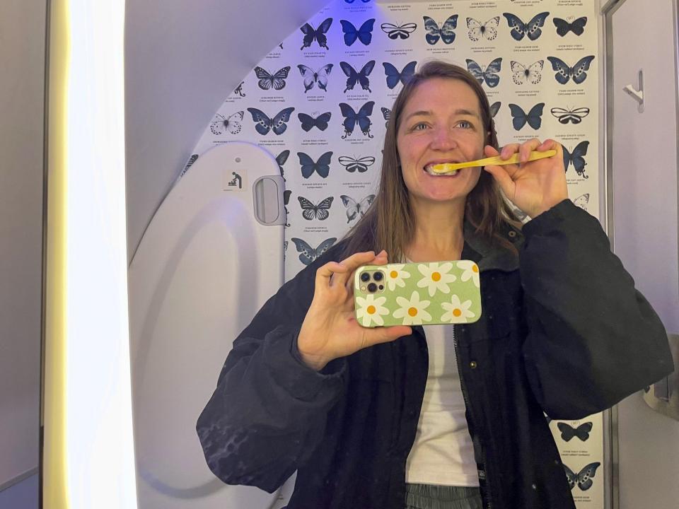 The author brushes her teeth in the airplane bathroom on a long-haul flight to Auckland, New Zealand.