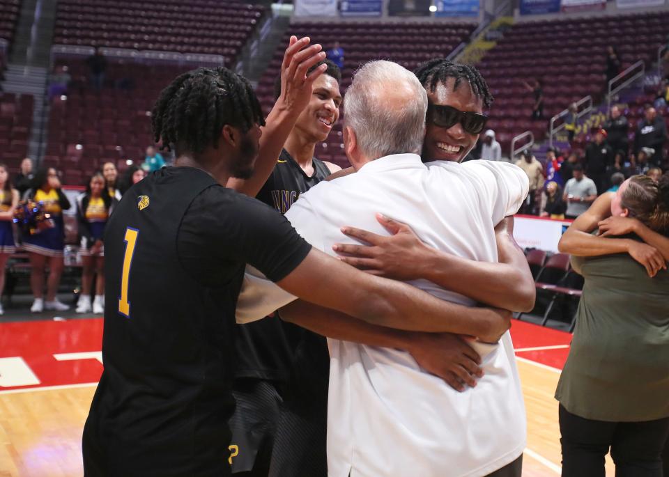 Lincoln Park's DeAndre Moye, Meleek Thomas, and Dontay Green hug head coach Mike Bariski after the Leopards defeated Neumann Goretti 62-58 in the PIAA 4A Championship game Thursday night at the Giant Center in Hershey, PA.