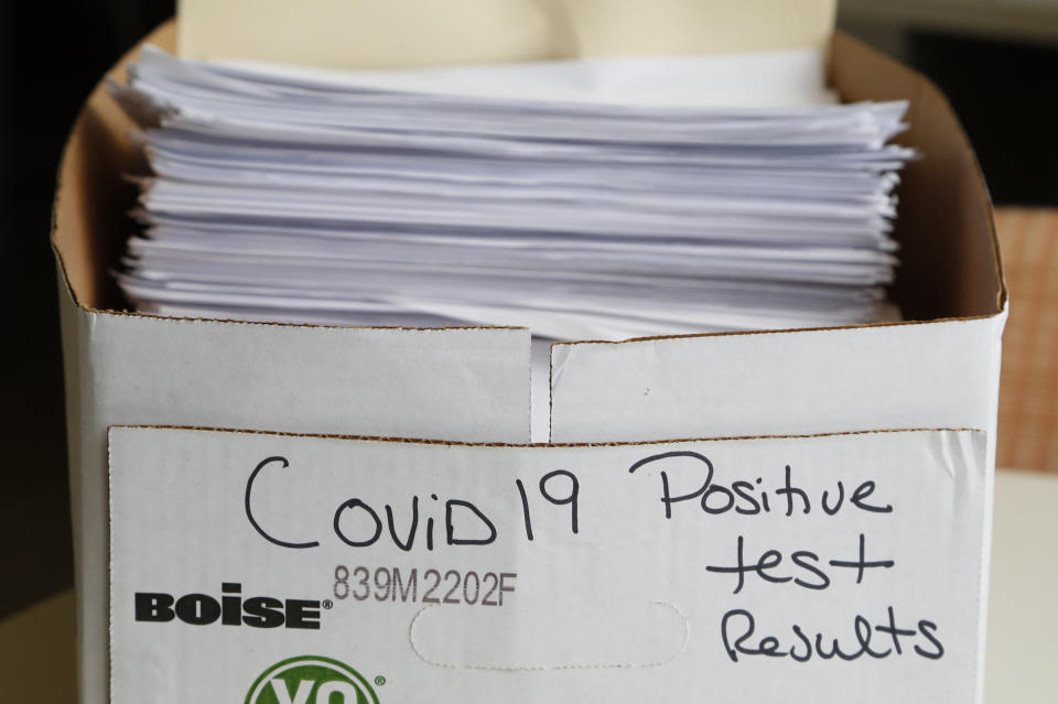 Una pila de documentos detallando los casos positivos de COVID-19, en una caja en las oficinas del Departamento de Salud Pública del condado Toledo-Lucas, en Ohio, el 24 de junio de 2020. Desde 2010, el gasto para los departamentos de salud pública estatales ha disminuido un 16% per cápita, y el gasto para los departamentos de salud locales ha bajado un 18%, según un análisis de KHN y The Associated Press. (AP Foto/Paul Sancya)