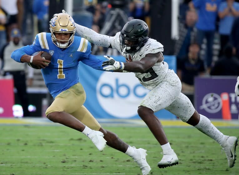 PASADENA, CALIF. - OCT. 23, 2021. UCLA quarterback Dorian Thompson-Robinson is brought down for a loss.
