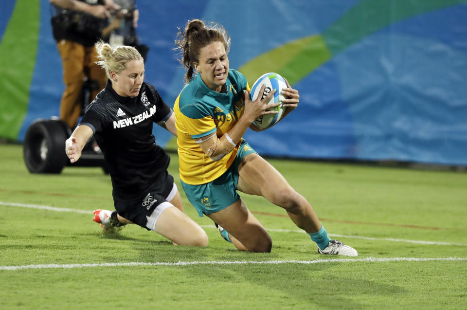 FILE - In this Aug. 8, 2016, file photo, Australia's Evania Pelite, right, scores a try as New Zealand's Kelly Brazier chases during the women's rugby sevens gold medal match at the Summer Olympics in Rio de Janeiro, Brazil. It was rugby in fast forward and it generated millions of new fans across the world. Rugby sevens made its Olympic debut in Rio de Janeiro in 2016 bringing all the usual hard-hitting tackles, collisions and swerving runs but leaving out the slow-mo elements of the traditional 15-a-side game. (AP Photo/Themba Hadebe, File)