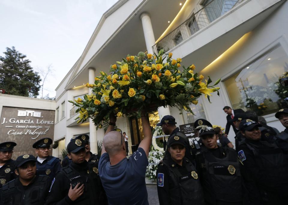 A man carries a flower wreath outside the funeral home where the body of Colombian Nobel Prize laureate Garcia Marquez was taken to, in Mexico City