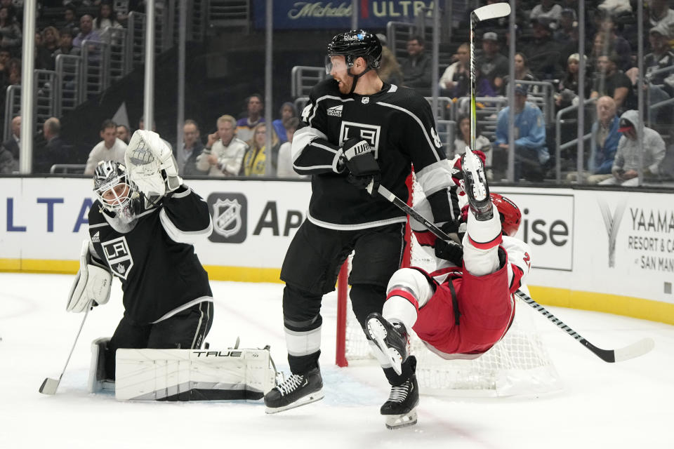 Los Angeles Kings defenseman Vladislav Gavrikov, center, upends Carolina Hurricanes center Seth Jarvis, right, as goaltender Pheonix Copley is scored on during the first period of an NHL hockey game Saturday, Oct. 14, 2023, in Los Angeles. (AP Photo/Mark J. Terrill)