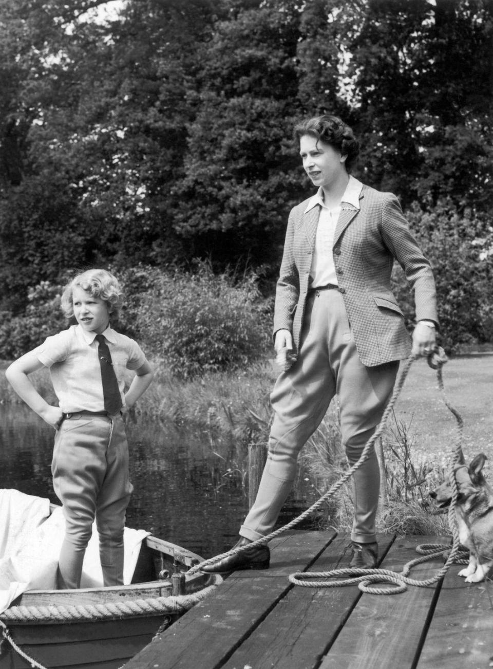 <p>Queen Elizabeth and Princess Anne prepare for a boat ride on Frogmore Lake at Windsor Castle. One of the family's corgis helps.<br></p>