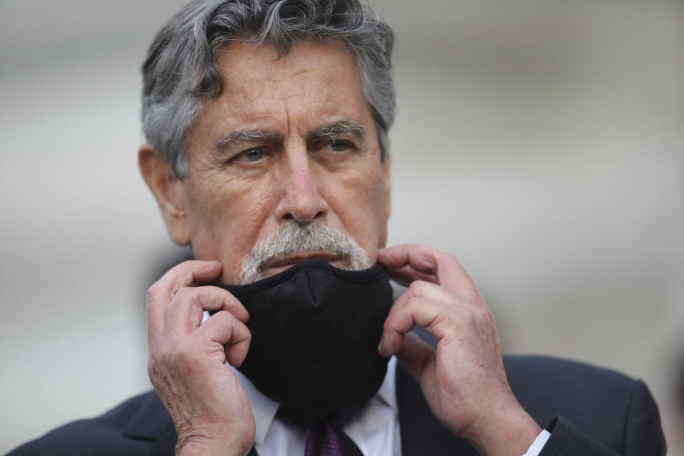 Peru's new interim President Francisco Sagasti takes off his mask after he was designated by Congress to lead the nation, in Lima, Peru, Monday, Nov. 16, 2020. Lawmakers chose Sagasti to become the nation's third president in the span of a week after they ousted Martin Vizcarra and the following protests forced his successor Manuel Merino to resign. (AP Photo/Rodrigo Abd)