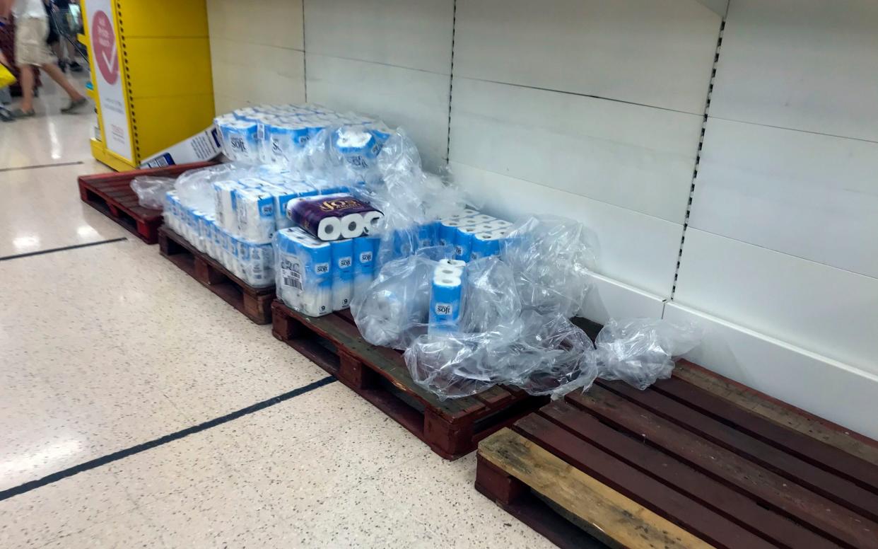 Depleted stocks and empty pallets can be seen in the toilet roll aisle at a Tesco store in Portsmouth North Harbour - Steve Parsons/PA