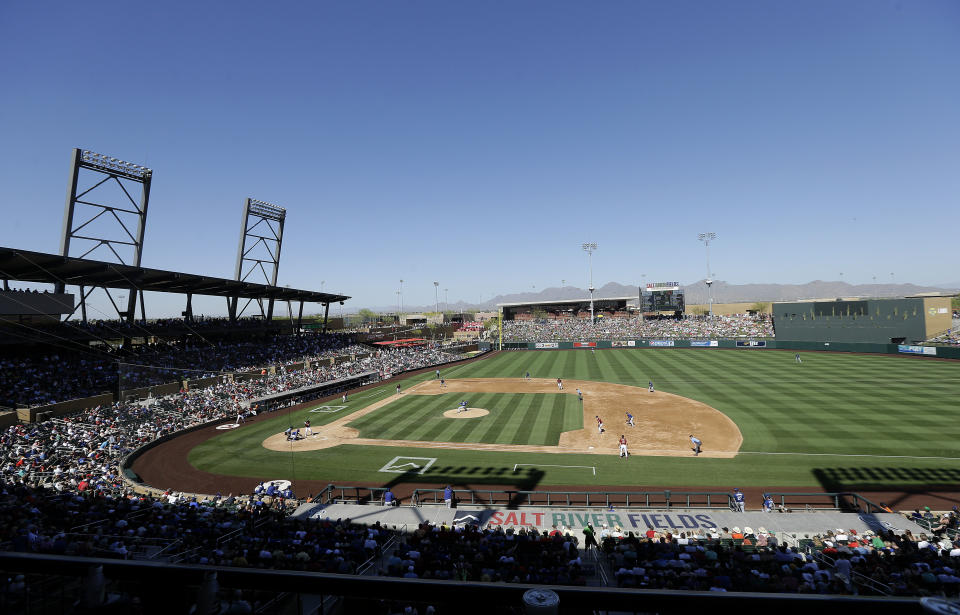 FILE - In this March 18, 2016, file photo, fans at Salt River Fields at Talking Stick watch a spring training baseball game between the Arizona Diamondbacks and the Los Angeles Dodgers in Scottsdale, Ariz. The Diamondbacks sold out their entire spring allotment of tickets in less than 24 hours after they went on sale to the public. Approximately 2,200 tickets were sold for all 14 of the team's home games, with fans spread throughout the park in pods of two, four or six seats and masks are required except when eating or drinking. (AP Photo/Jeff Chiu, File)