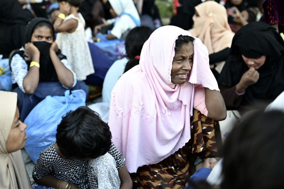 An ethnic Rohingya woman weeps after being removed from their temporary shelter at the basement of a community hall during a protest rejecting Rohingya refugees in Banda Aceh Aceh province, Indonesia, Wednesday, Dec. 27, 2023. Students in Indonesia's Aceh province rallied on Wednesday demanding the government drive away Rohingya refugees arriving by boat in growing numbers as police named more suspects of human trafficking. (AP Photo/Reza Saifullah)