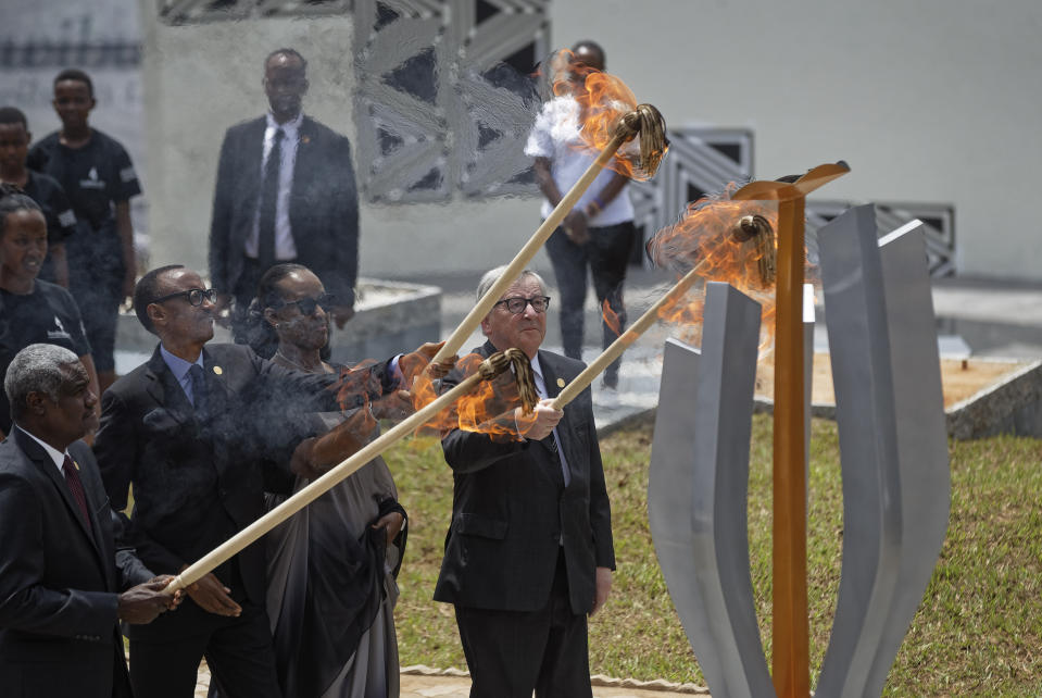 From left to right, Chairperson of the African Union Commission Moussa Faki Mahamat, Rwanda's President Paul Kagame, Rwanda's First Lady Jeannette Kagame, and President of the European Commission Jean-Claude Juncker, light the flame of remembrance at the Kigali Genocide Memorial in Kigali, Rwanda, Sunday, April 7, 2019. Rwanda is commemorating the 25th anniversary of when the country descended into an orgy of violence in which some 800,000 Tutsis and moderate Hutus were massacred by the majority Hutu population over a 100-day period in what was the worst genocide in recent history. (AP Photo/Ben Curtis)