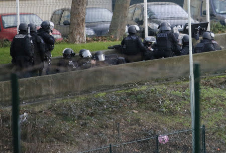 A member of the French police special forces takes position near the scene of a hostage taking at a kosher supermarket near the Porte de Vincennes in eastern Paris January 9, 2015. REUTERS/Gonzalo Fuentes