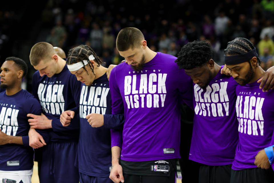 Sacramento Kings and Denver Nuggets players lock arms before the game at Golden 1 Center during a moment of silence for the events going on in Ukraine. Alex Len, center, is one of two Ukrainian NBA players.