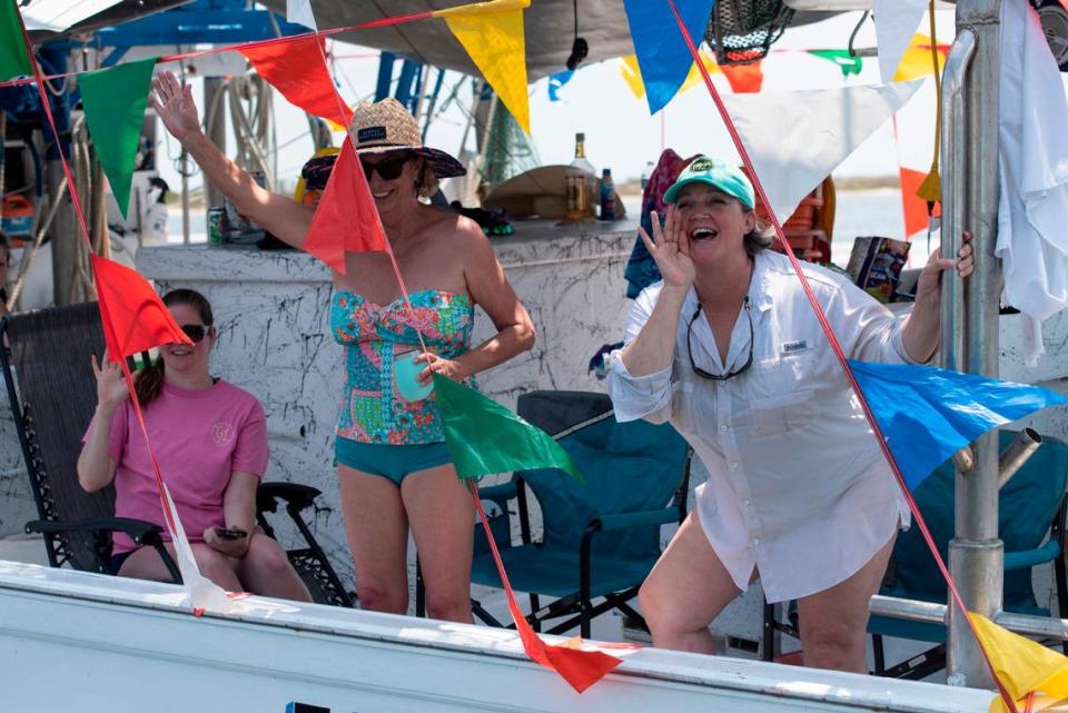 People on a boat wave to Msgr. Dominick Fullam and the Shrimp King and Queen as they receive a blessing during the Blessing of the Fleet in Biloxi on Sunday, May 28, 2023.