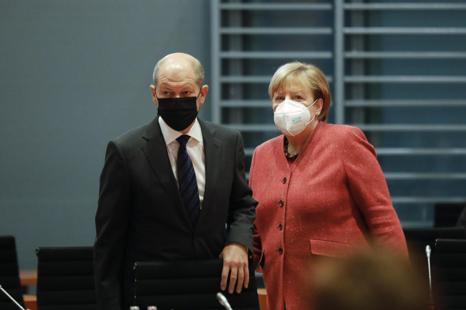 FILE - In this Nov. 11, 2020 file photo, German Chancellor Angela Merkel, right, and German Finance Minister Olaf Scholz arrive at the weekly cabinet meeting of the German government at the chancellery in Berlin, Germany. German lawmakers presenting a report into the collapse of payment processing company Wirecard accused the country's finance minister and auditors Ernst and Young of numerous oversight failings. (AP Photo/Markus Schreiber, Pool, File)