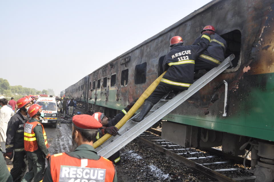 Rescue workers look for survivors following a train damaged by a fire in Liaquatpur, Pakistan, Thursday, Oct. 31, 2019. A massive fire engulfed three carriages of the train traveling in the country's eastern Punjab province (AP Photo/Siddique Baluch)