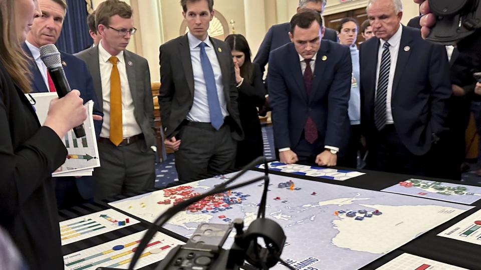 Lawmakers in a new House select committee on China gather for a tabletop war game exercise in the House Ways and Means Committee room on Wednesday, April 19, 2023, in Washington. Center of New American Security think tank defense program director Stacie Pettyjohn, left, Rep. Dusty Johnson, R-S.D., third from left,  Rep. Jake Auchincloss, D-Mass., fourth from left, Rep. Haley Stevens, D-Mich., committee Chairman Mike Gallagher, R-Wis., second from right, and Rep. Carlos Gimenez, R-Fla. (Ellen Knickmeyer/AP)