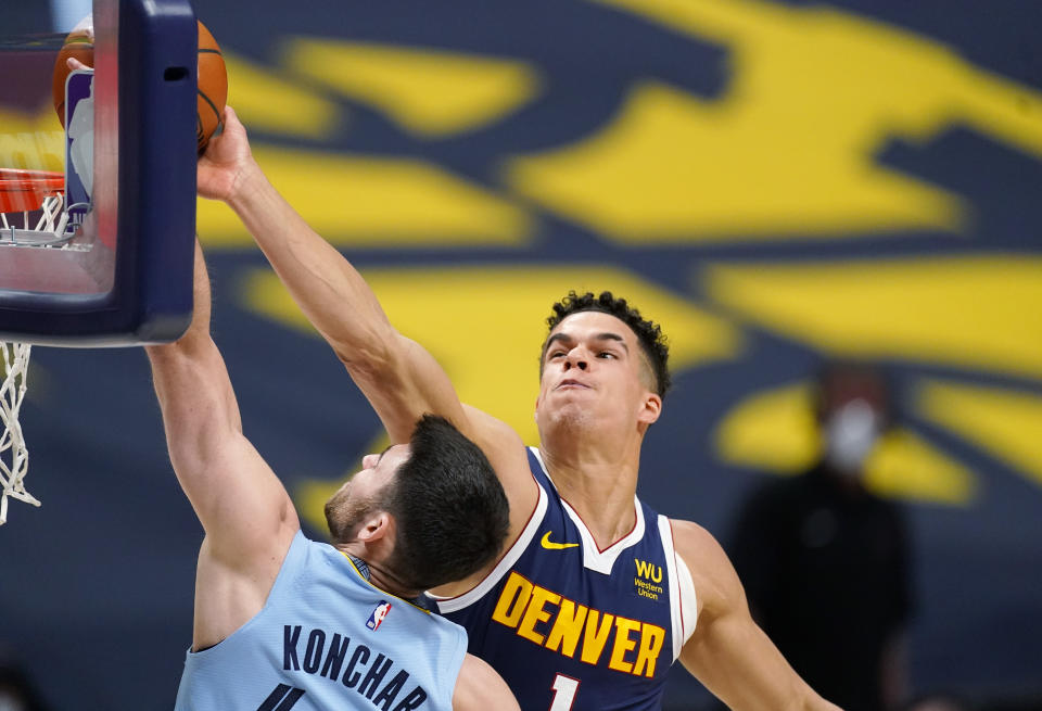 Denver Nuggets forward Michael Porter Jr., right, blocks a shot by Memphis Grizzlies guard John Konchar in the first half of an NBA basketball game Monday, April 19, 2021, in Denver. (AP Photo/David Zalubowski)