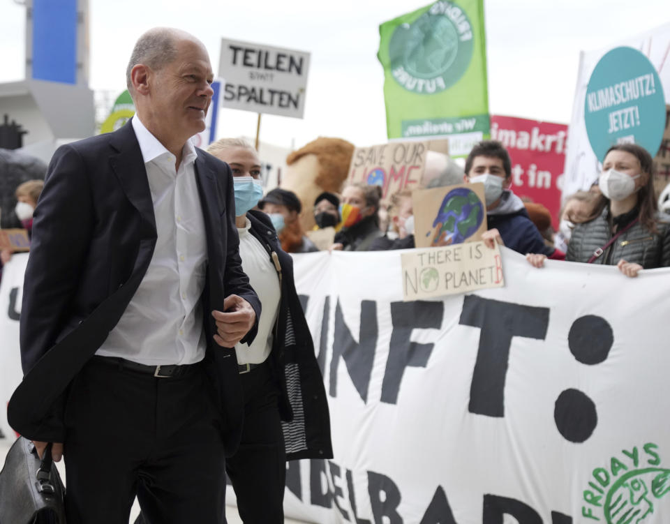 Olaf Scholz, SPD candidate for Chancellor and Federal Minister of Finance, arrives at the venue for exploratory talks between the SPD, FDP and the Green Party on the formation of a new federal government after the Bundestag elections in Berlin, Germany, Friday, Oct. 15, 2021. He will be met by Fridays for Future activists, Greenpeace and the campaign organisation Campact, who are demonstrating for climate protection and against arms exports. The SPD, the Greens and the FDP want to agree on a basis for decision-making for coalition negotiations that summarizes the outcome of the negotiations so far. (Kay Nietfeld/dpa via AP)