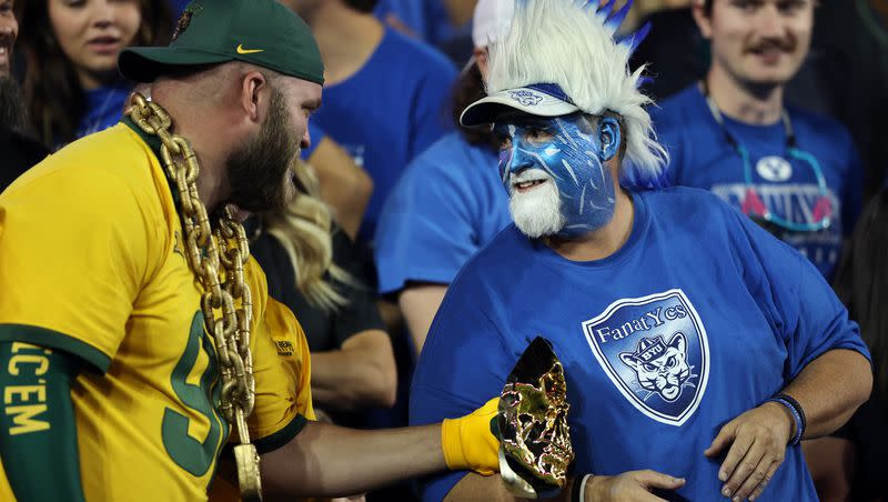A Baylor fan and a BYU fan talk after BYU scored a touchdown as the two schools play football at LaVell Edwards Stadium in Provo on Saturday, Sept. 10, 2022. BYU goes to great lengths to ensure visiting fans have a positive experience in Provo.