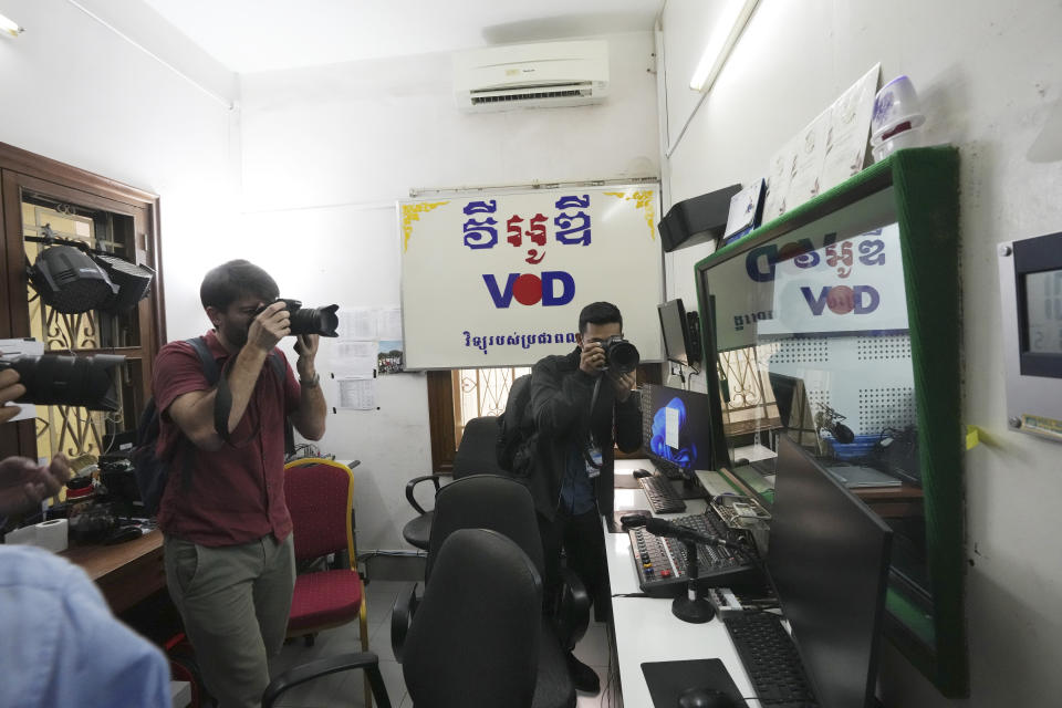 Journalists take photographs at a newsroom of the Voice of Democracy, VOD office in Phnom Penh, Cambodia, Monday, Feb. 13, 2023. Cambodia's Prime Minister Hun Sen on Sunday, Feb. 12, ordered one of the handful of independent media broadcasters to shut down for publishing an article he said intentionally slandered his son in connection with the country's relief assistance to earthquake victims in Turkey. (AP Photo/Heng Sinith)