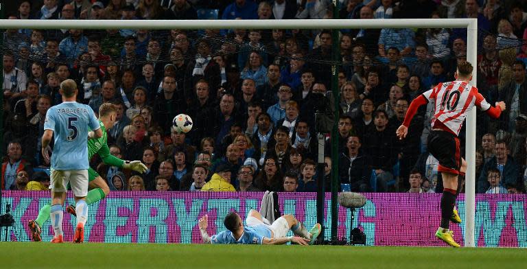 Sunderland's Connor Wickham (R) scores during their 2-2 English Premier League draw against Manchester City at the Etihad Stadium on April 16, 2014