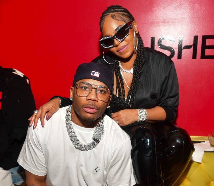 A closeup of Nelly and Ashanti sitting on a couch at an event