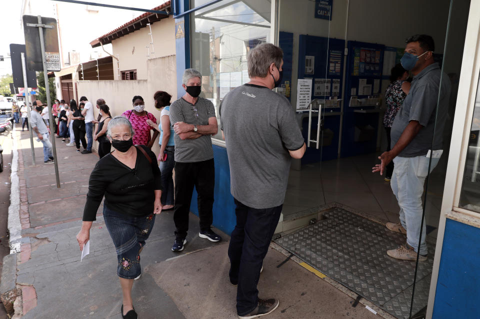 Gente haciendo cola a la entrada de un establecimiento de lotería en Brasil