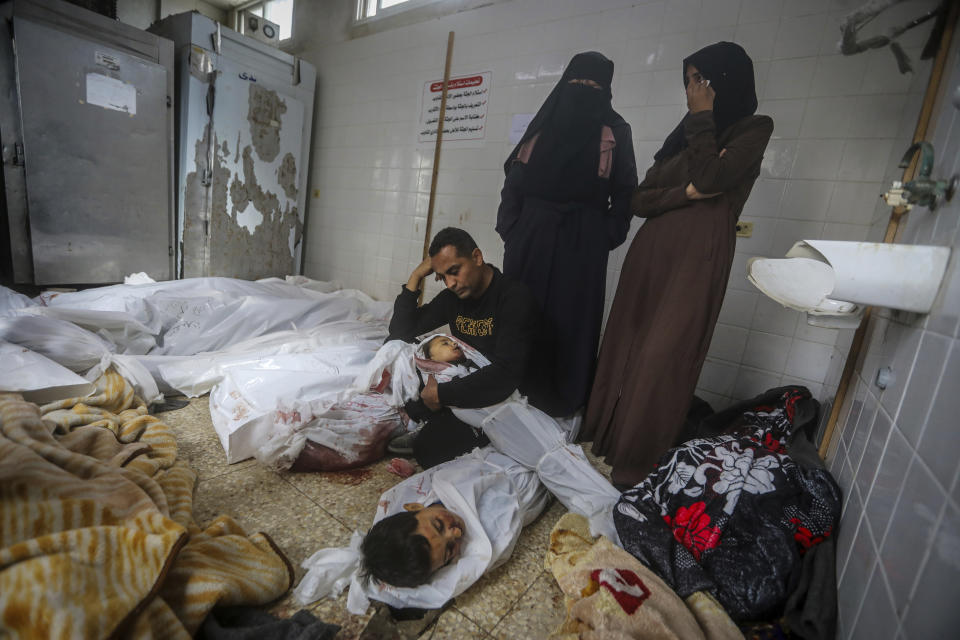 Palestinians mourn over the bodies of their relatives killed in the Israeli bombardment of the Gaza Strip at the morgue of Al Aqsa Hospital in Deir al Balah, Gaza Strip, Wednesday, April 10, 2024. (AP Photo/Ismael Abu Dayyah)