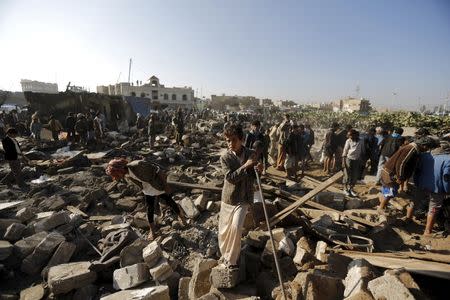 People gather at the site of an air strike at a residential area near Sanaa Airport March 26, 2015. REUTERS/Khaled Abdullah