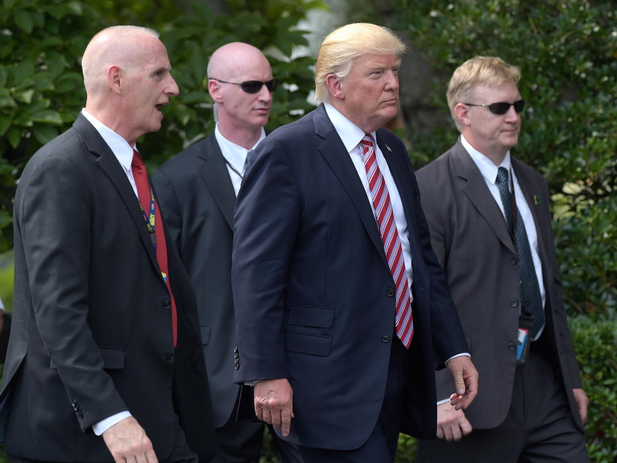 President Donald Trump, his longtime bodyguard Keith Schiller, left, and two Secret Service agents walk along the South Lawn of the White House: AP