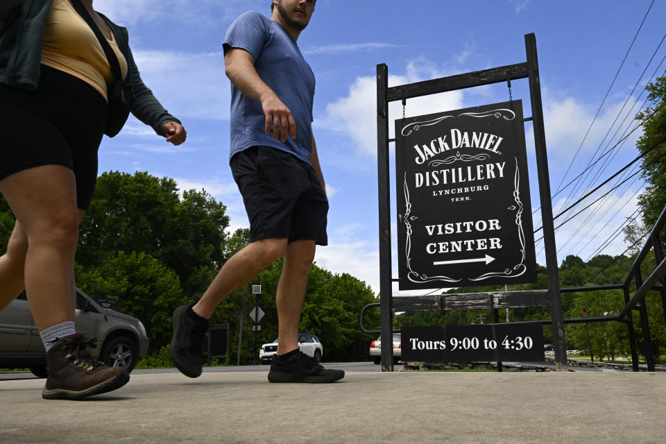 Visitors walk to the Jack Daniels Distillery visitor center Wednesday, June 14, 2023, in Lynchburg, Tenn. A destructive and unsightly black fungus which feeds on ethanol emitted by whiskey barrels has been found growing on property near the distillery's barrelhouses. (AP Photo/John Amis)