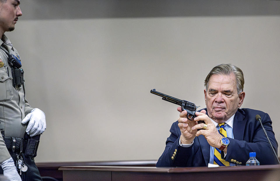 Santa Fe County Deputy Levi Abeyta, left, watches as firearms expert for the defense Frank Koucky III demonstrates how to uncock a gun like the one used on the set of the movie "Rust" as Koucky testifies in the involuntary manslaughter trial of movie armorer Hannah Gutierrez-Reed, Tuesday, March 5, 2024, at the First Judicial District Courthouse in Santa Fe, N.M. (Jim Weber/Santa Fe New Mexican via AP, Pool)