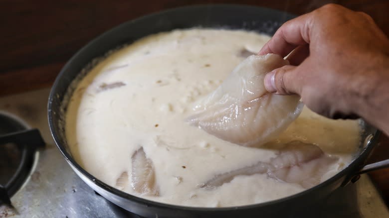 adding tilapia filets to coconut broth