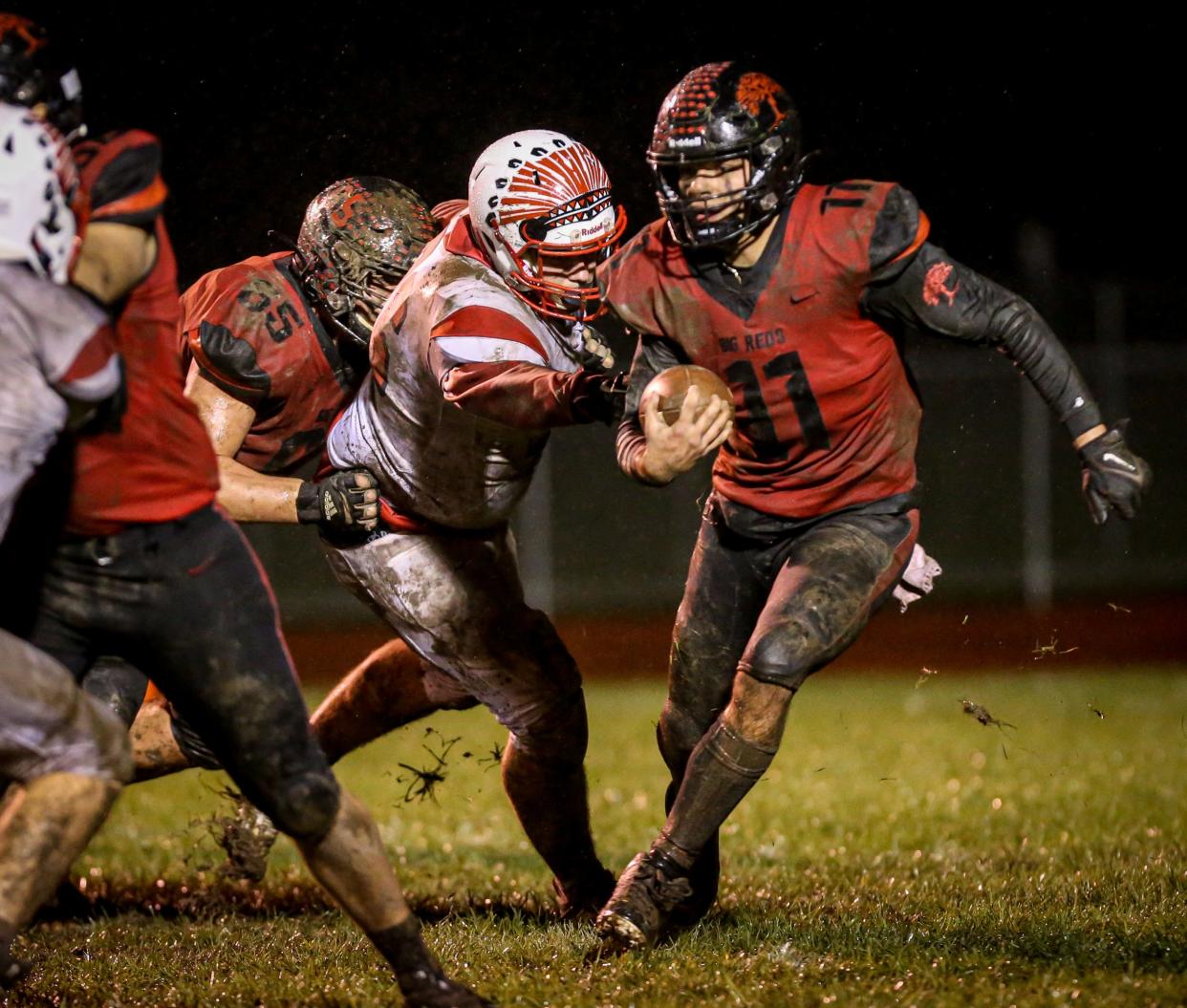 Milan's Cole McElvany carries the ball in the fourth quarter against New Boston Huron in the Division 4 playoff opener Friday, October 29, 2021.